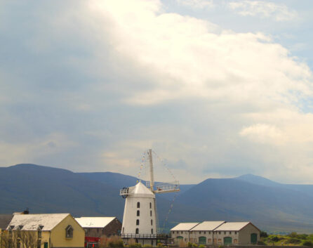 Scenic view of River Island Hotel with family exploring, mountains in background, sunny day.