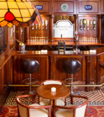 Cosy hotel bar with wooden decor and seating, featuring River Island Hotel signage.