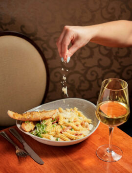 A cosy dining scene with pasta and wine at River Island Hotel.