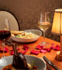 Cosy dinner setting with wine and gourmet dishes at River Island Hotel restaurant.
