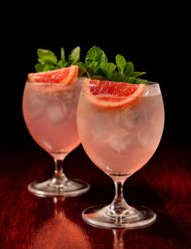Refreshing gin cocktails garnished with grapefruit and mint.
