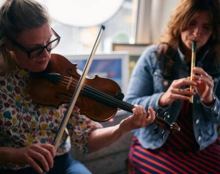 Two women playing traditional Irish music in a warm, cosy hotel lounge.