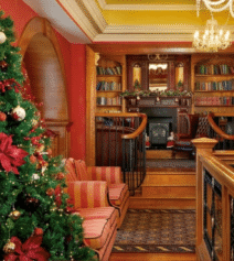 Festive hotel lounge with Christmas tree and cosy seating area.