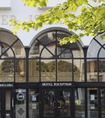 Elegant entrance of River Island Hotel with signs for reception and Con’s Bar & Grill.