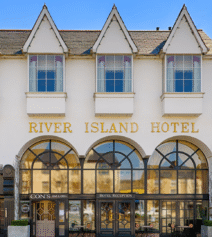 A family enters River Island Hotel with its elegant facade and welcoming entrance.