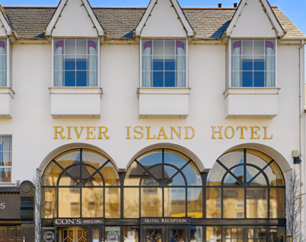 A family enters River Island Hotel with its elegant facade and welcoming entrance.