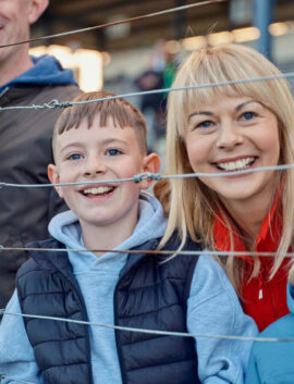 Smiling family enjoying a day at a local sports event near River Island Hotel.