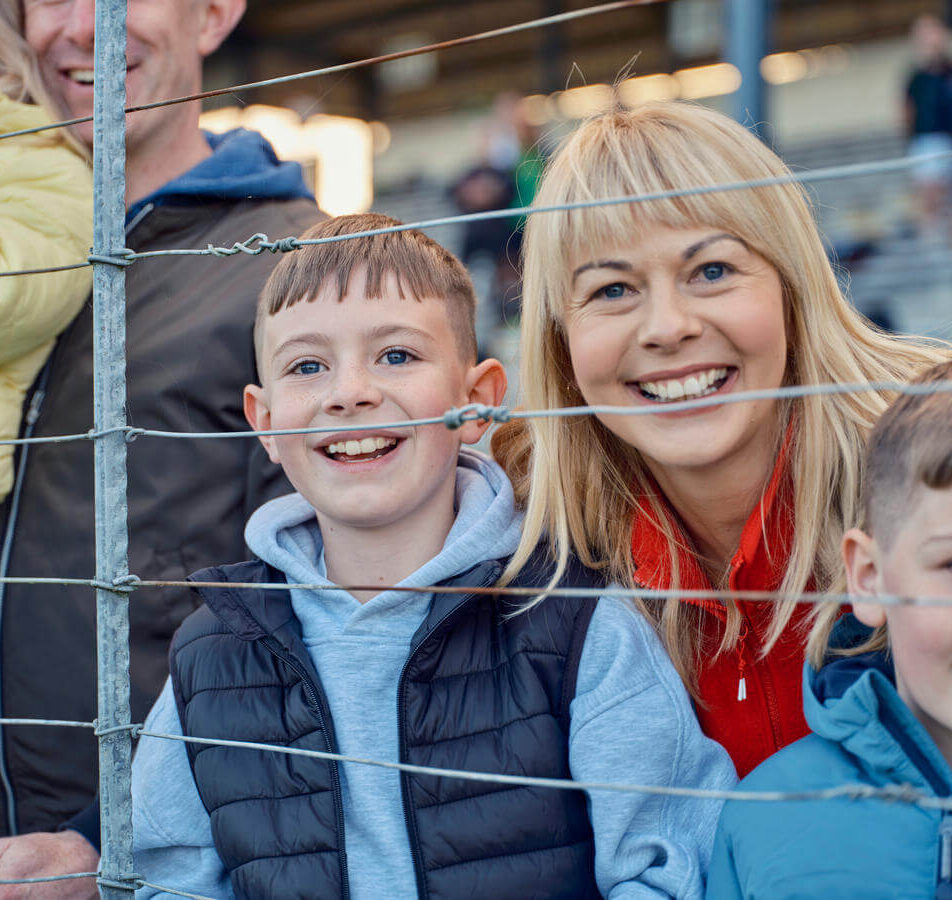 Smiling family enjoying a day at a local sports event near River Island Hotel.