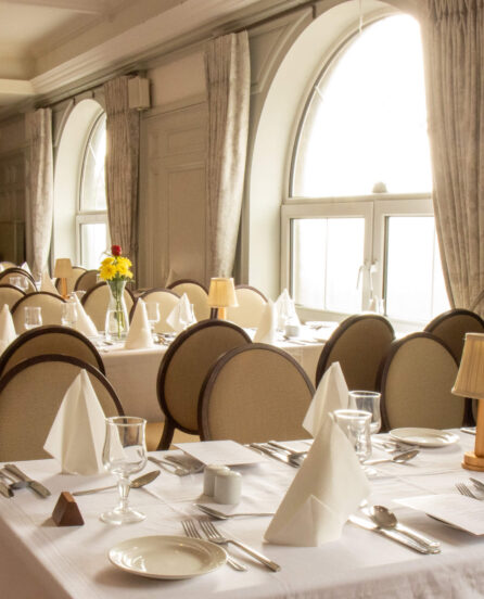 Elegant dining area setup at River Island Hotel with natural light and white linen tables.