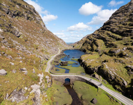 Family driving along scenic Ring of Kerry near River Island Hotel.