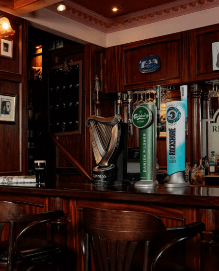Cosy hotel pub with wooden bar and River Island Hotel sign.