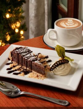 Festive dessert with chocolate cake and coffee in a cosy hotel setting.