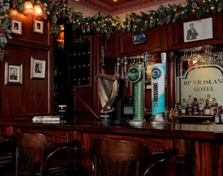Cosy hotel bar decorated for Christmas, with festive garlands and warm lighting.