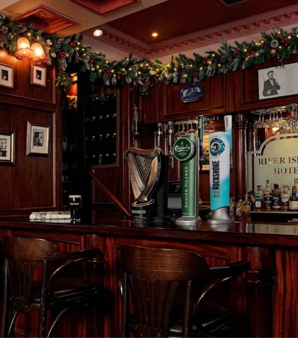 Cosy hotel bar decorated for Christmas, with festive garlands and warm lighting.