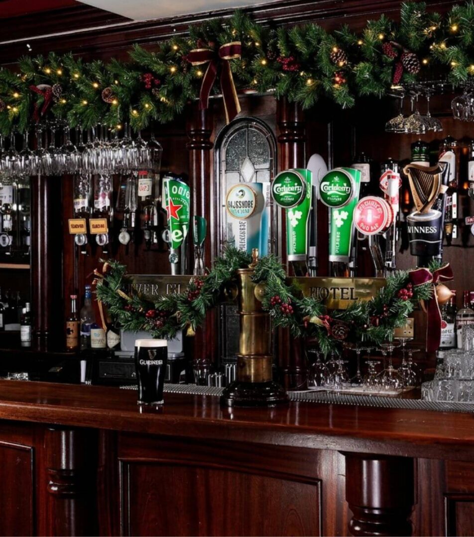 Festive hotel bar with Christmas decorations and taps, inviting guests for a cosy drink.