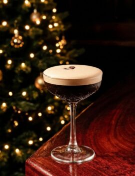 Festive cocktail on bar with Christmas tree in background at River Island Hotel.