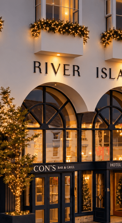 River Island Hotel's warmly lit entrance with festive decor and family entering.