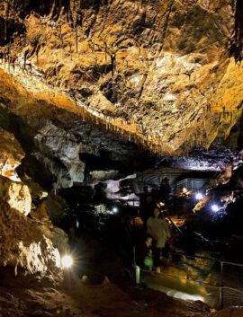 Family exploring illuminated cave near River Island Hotel in Kerry.