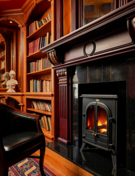 Cosy library with fireplace in River Island Hotel, perfect for relaxing by the fire.
