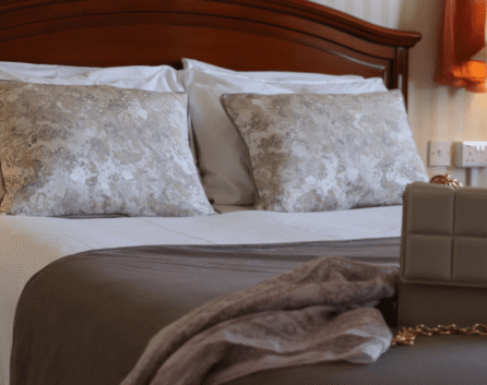 Elegant hotel room with comfy bed, plush pillows, and warm lighting at River Island Hotel.